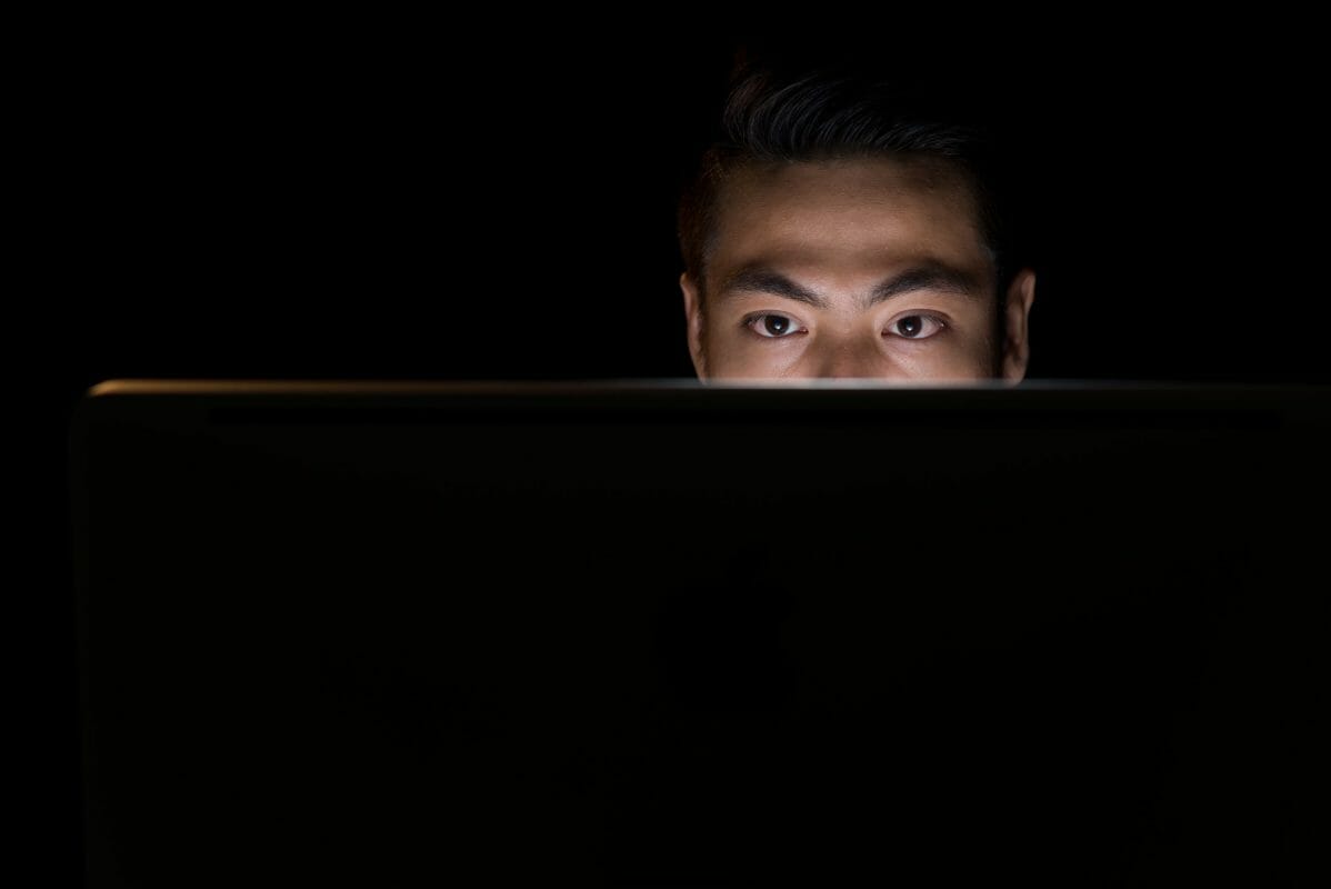 Asian-man-in-darkness-using-compute-536326-scaled.jpg